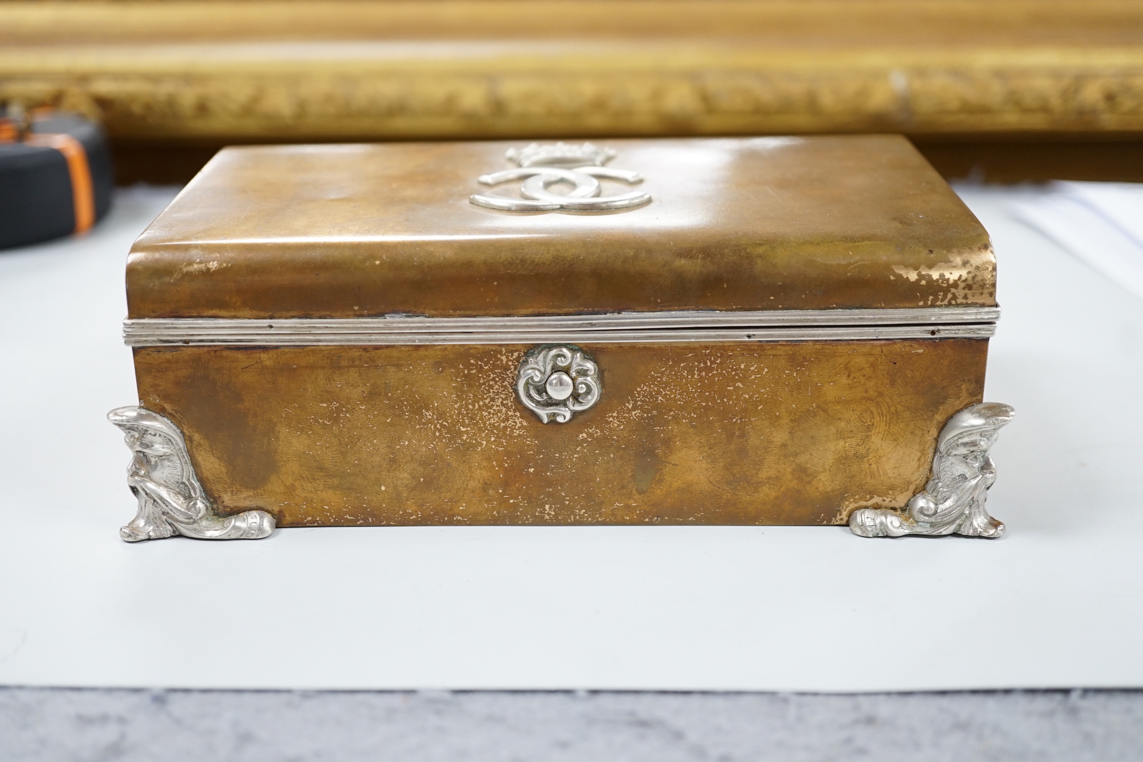 An unusual late Victorian silver mounted brass rectangular cigarette box, with applied monogram, Alfred Fuller, London, 1885, 16.4cm.